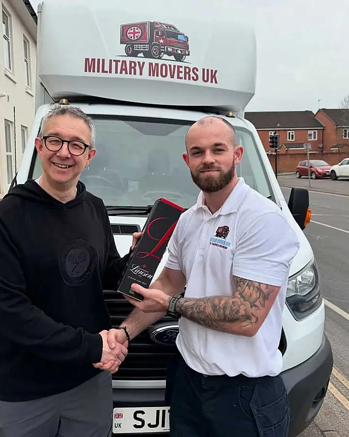 Military Movers UK team member shaking hands with a customer in front of a removals van